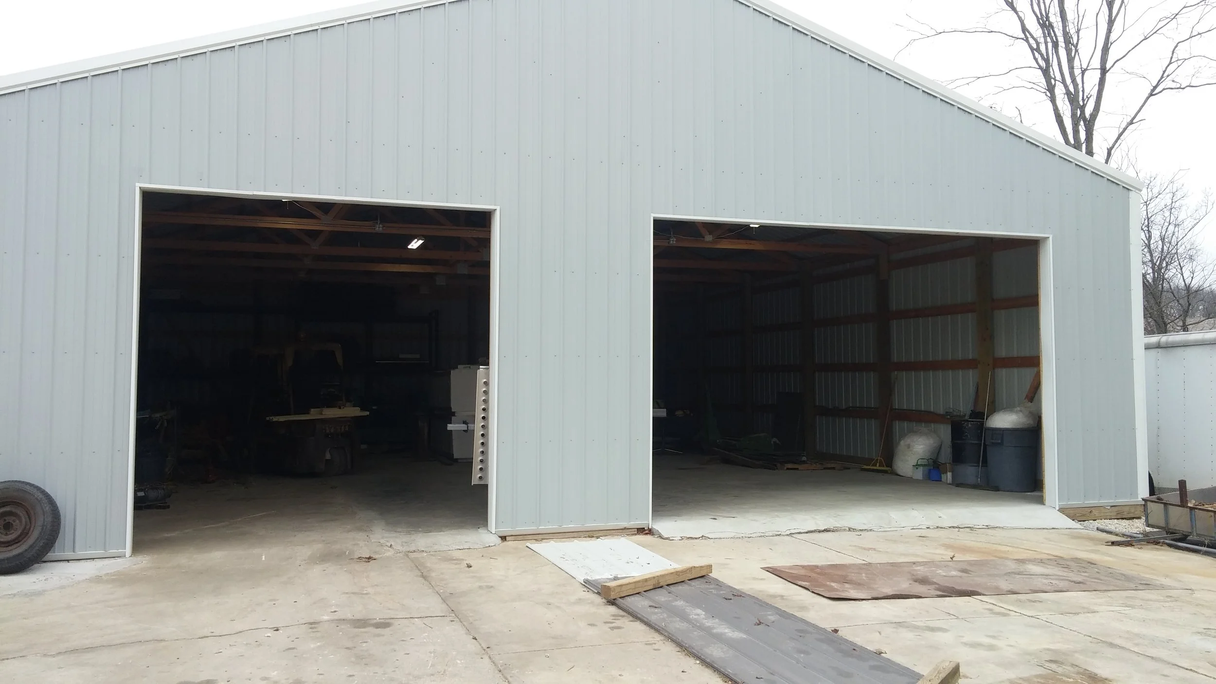 Commercial steel building with two large open garage door openings showing shop interior