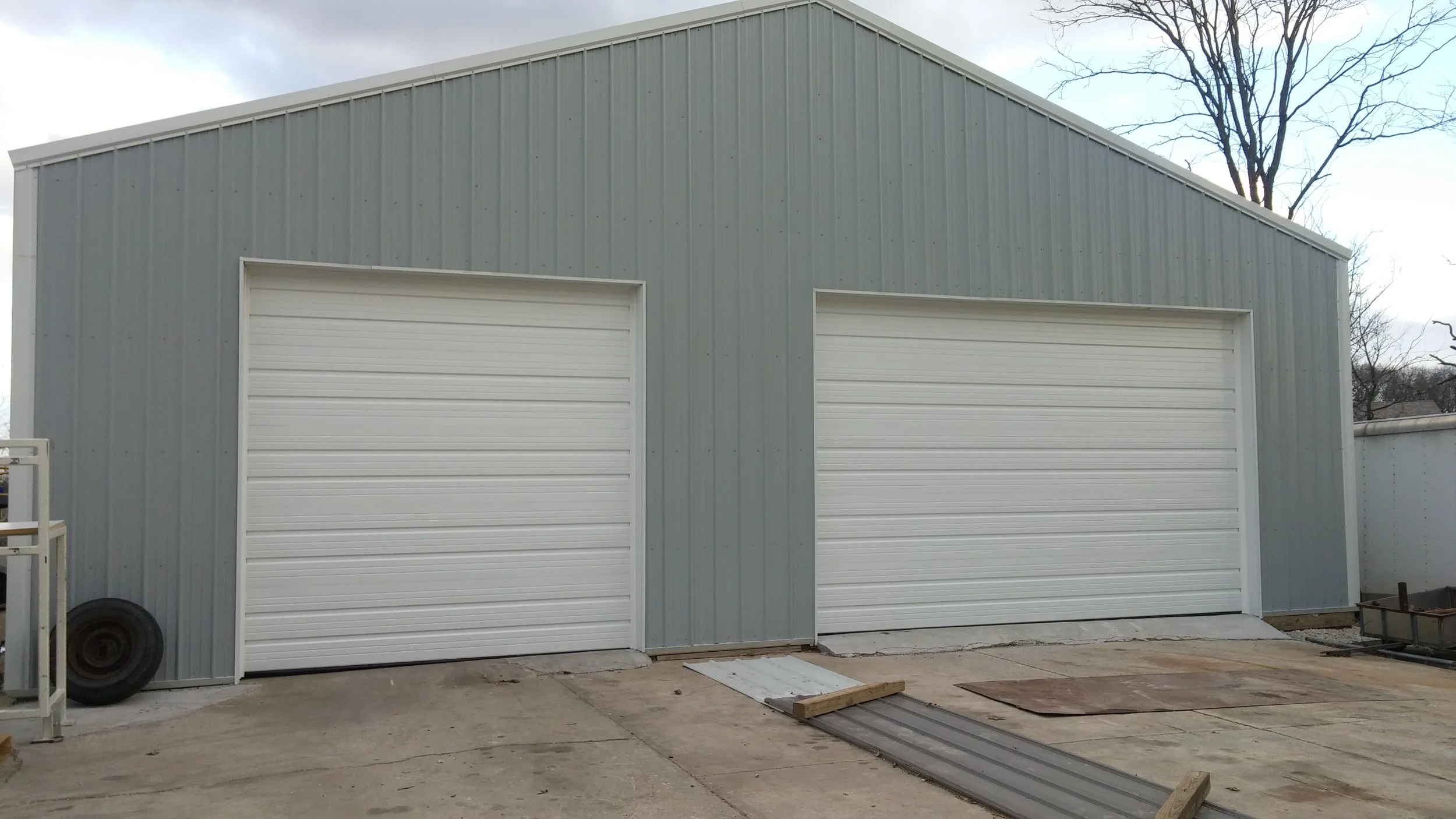 Commercial steel building with two newly installed white sectional garage doors