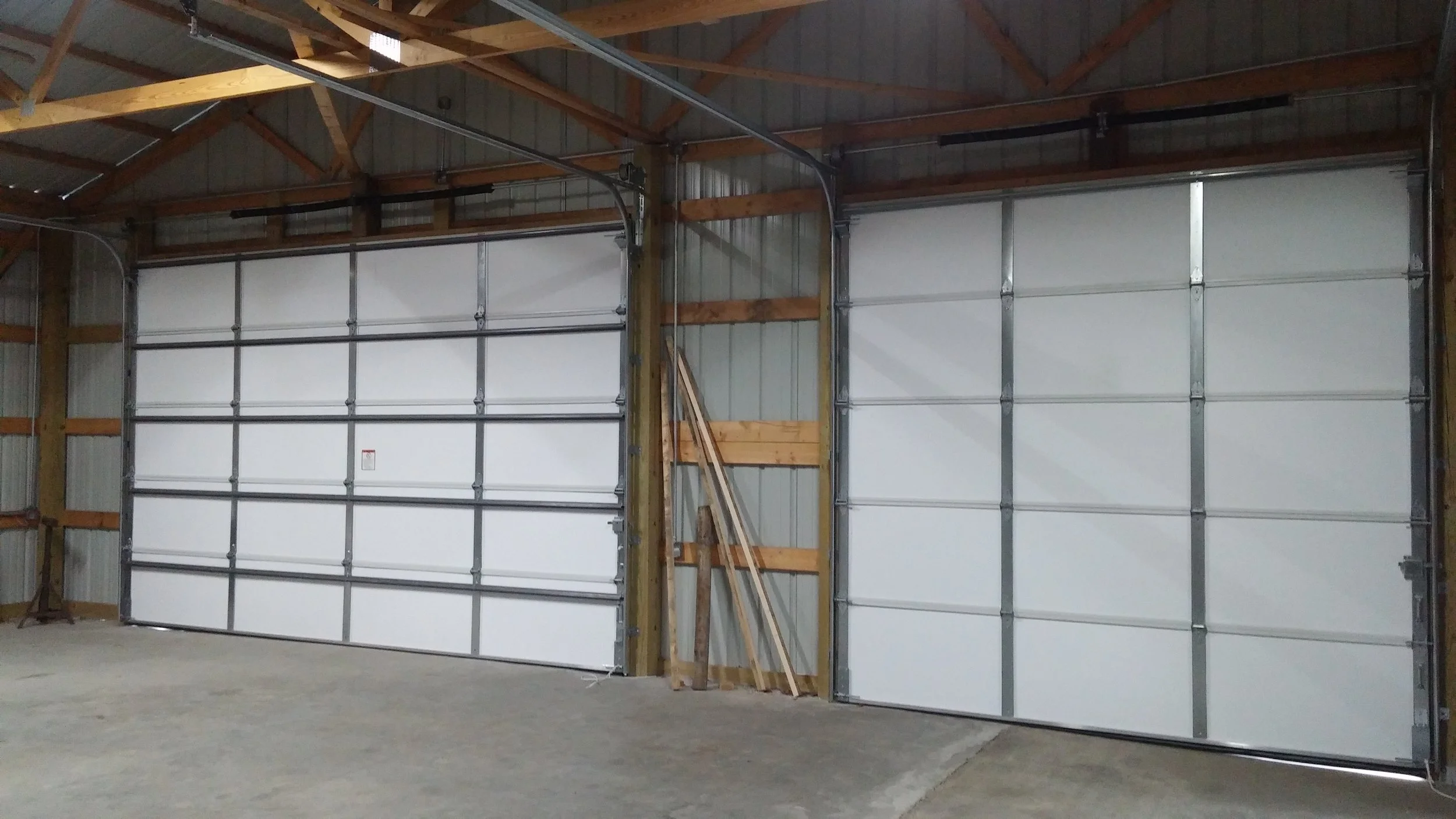 Side-by-side two-bay garage with stone and beige siding