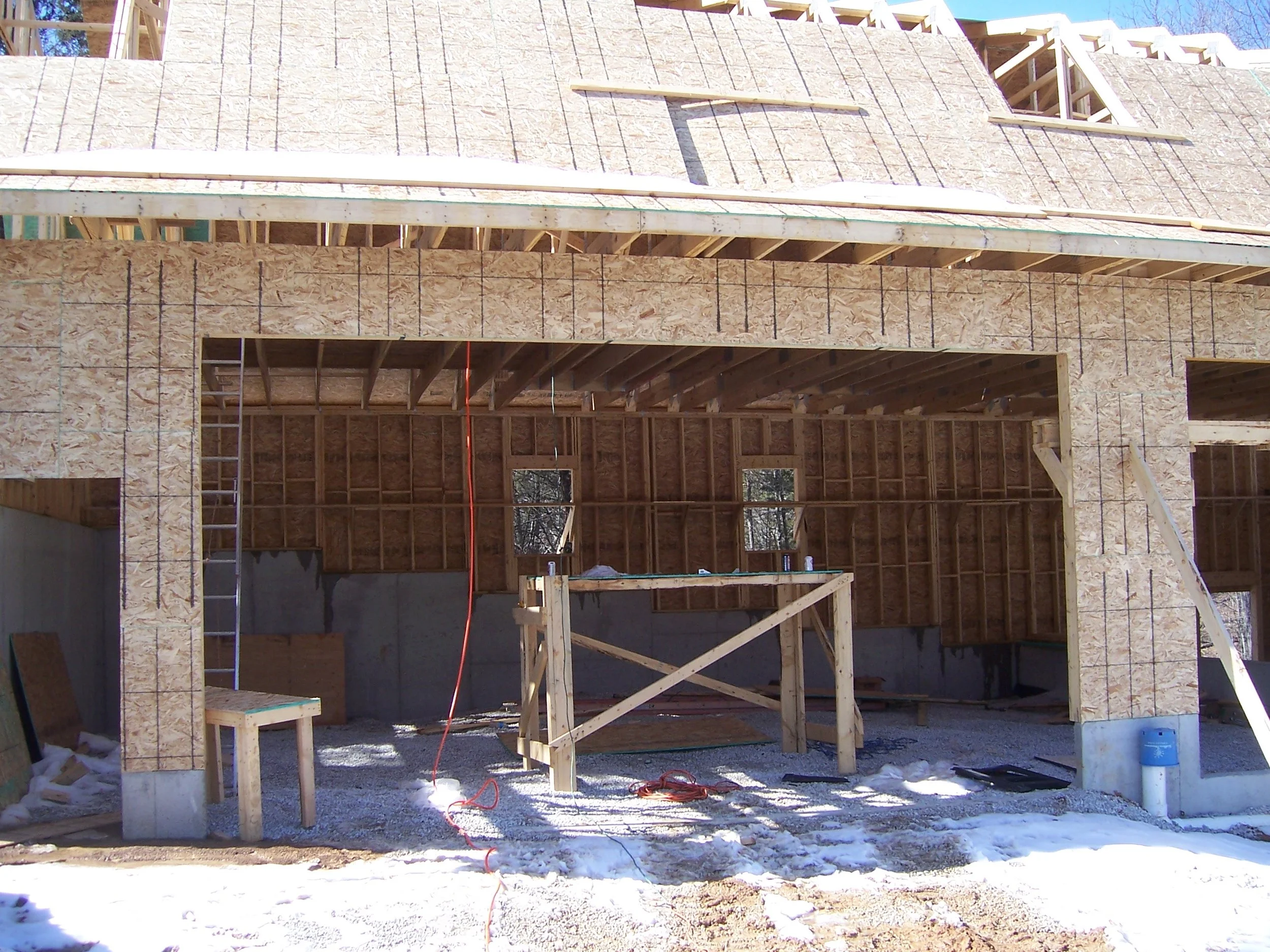 Wood-framed garage under construction with rough door openings