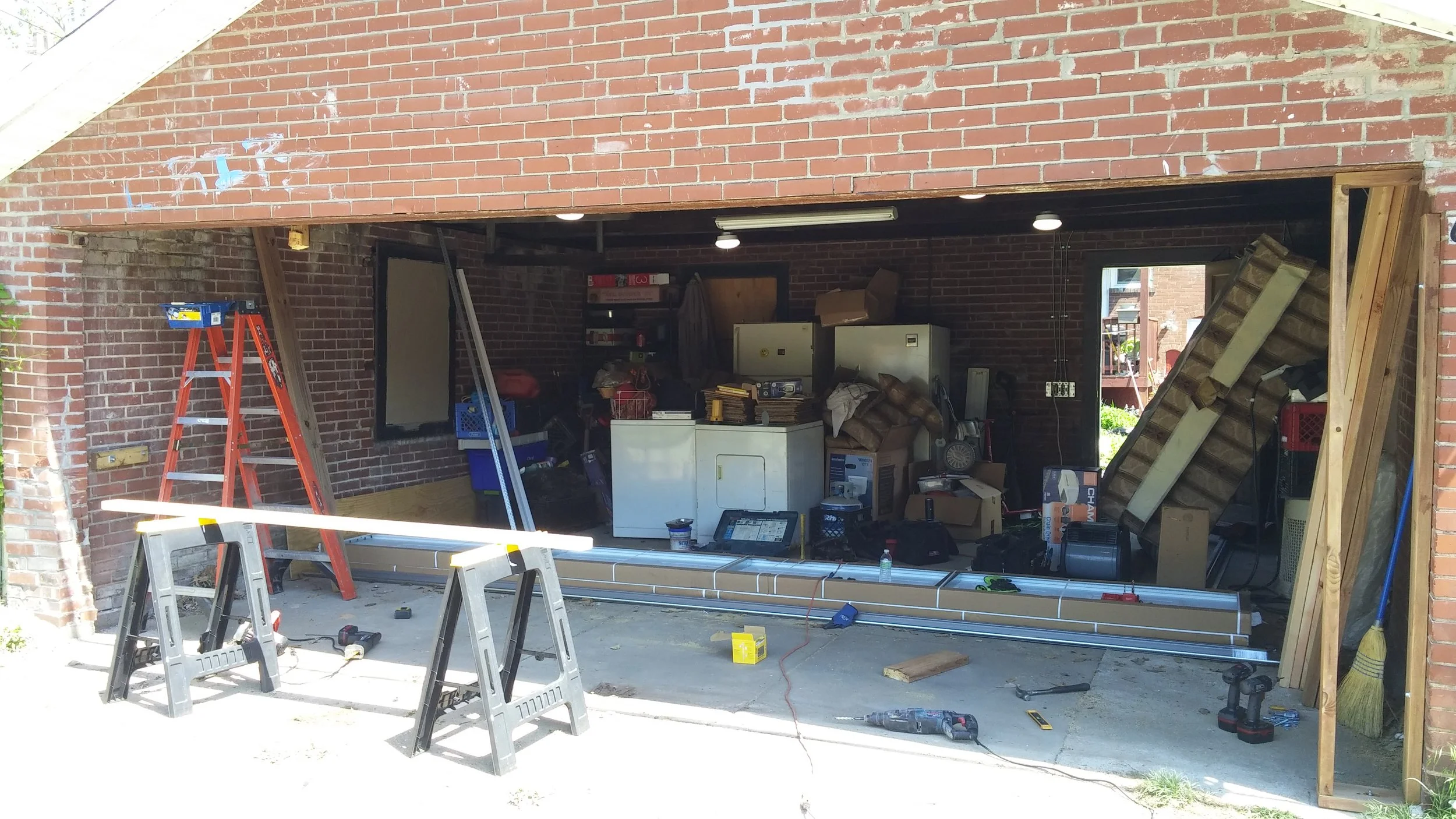 Wide shot of the brick garage with the rough opening cleared and framed