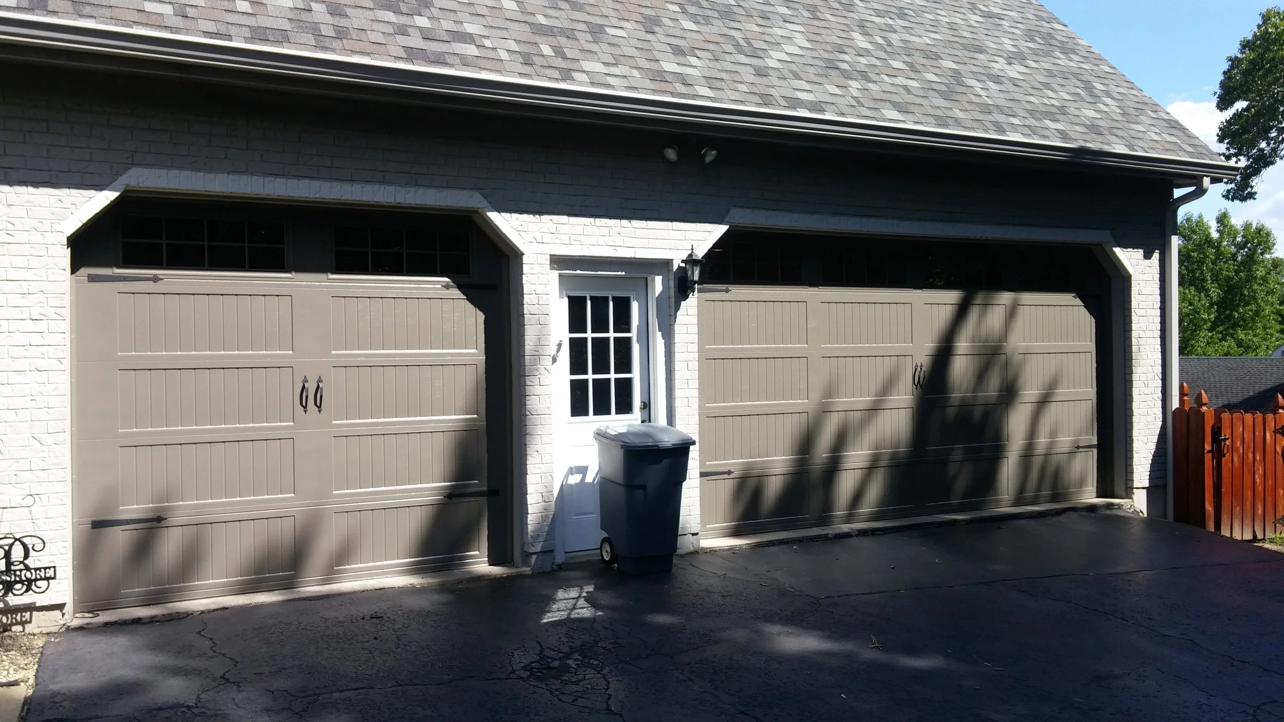 Recent install, two-bay residential garage with painted carriage-style sectional doors